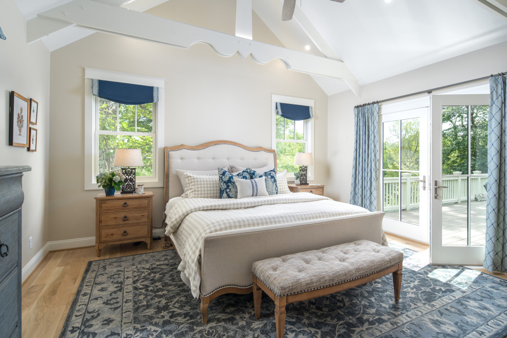 Foto di una camera da letto con pareti beige, pavimento in legno massello medio, pavimento marrone, travi a vista e soffitto a volta