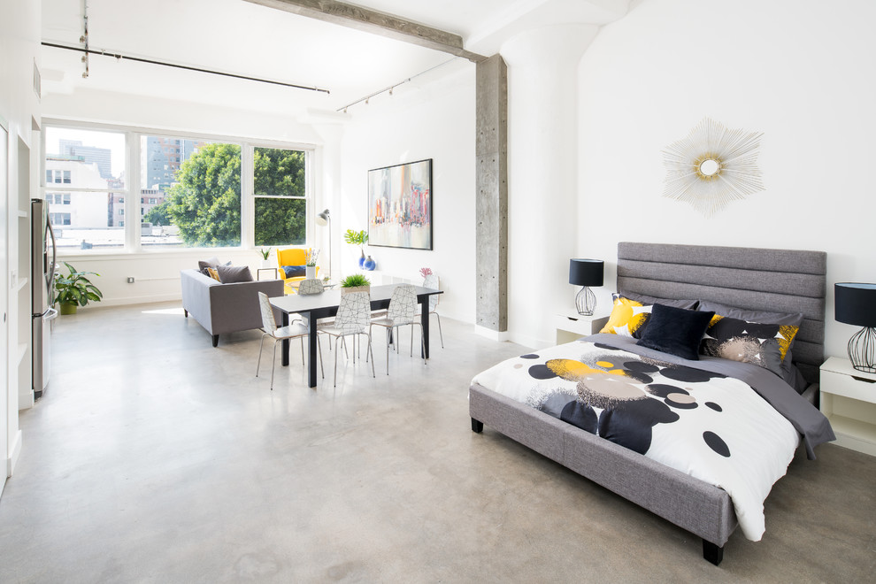 Idee per una camera da letto industriale di medie dimensioni con pareti bianche, pavimento in cemento e pavimento grigio