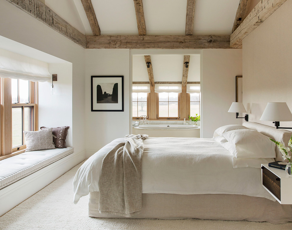 На фото: большая хозяйская спальня: освещение в стиле кантри с белыми стенами и ковровым покрытием с