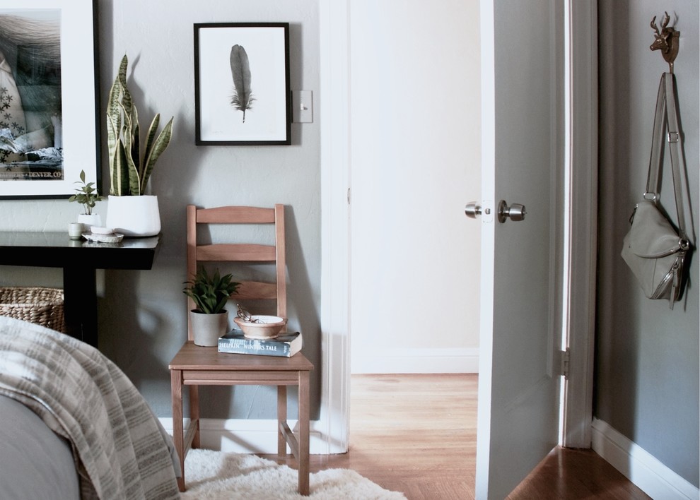 Imagen de habitación de invitados de estilo americano de tamaño medio sin chimenea con paredes grises y suelo de madera clara