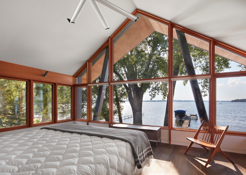 Пример оригинального дизайна: хозяйская спальня в стиле рустика с коричневым полом, белыми стенами и паркетным полом среднего тона