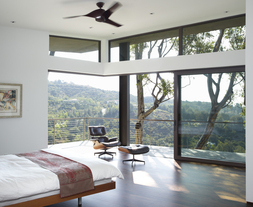 Medium sized modern master bedroom in Los Angeles with white walls and dark hardwood flooring.