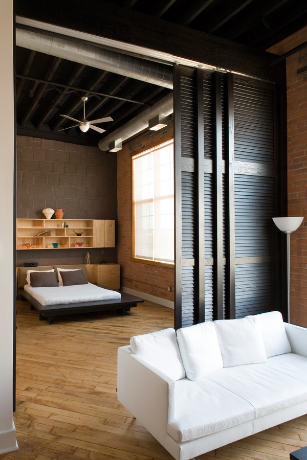 Imagen de dormitorio principal urbano pequeño con paredes grises y suelo de madera clara