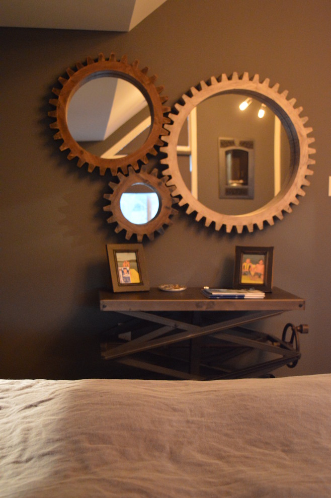 На фото: хозяйская спальня среднего размера в стиле лофт с серыми стенами, темным паркетным полом, стандартным камином и коричневым полом