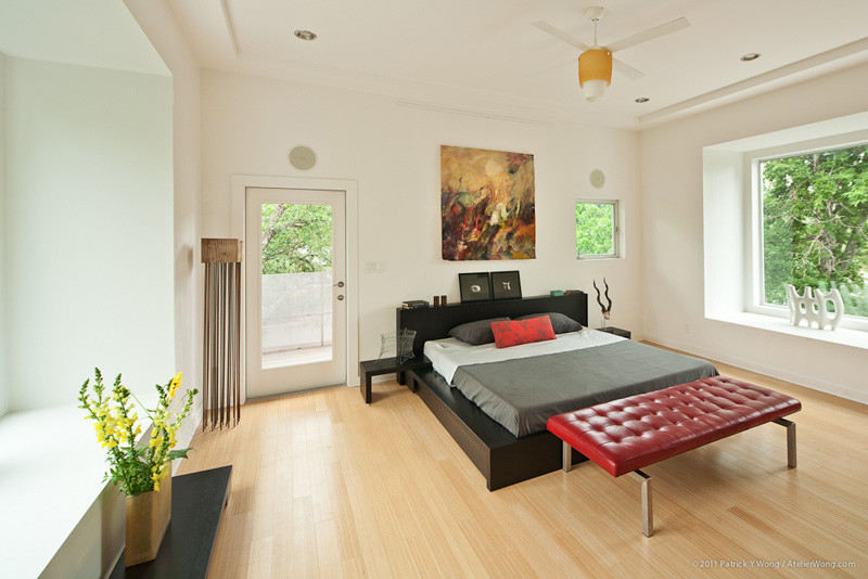 Small trendy master light wood floor bedroom photo in Austin with white walls and no fireplace