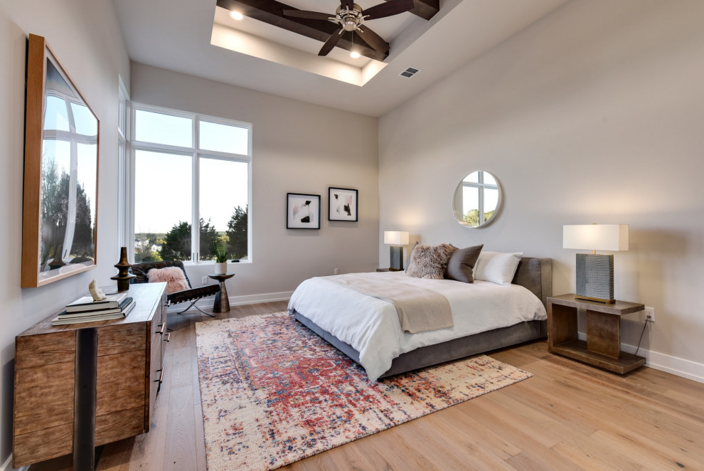 Modelo de dormitorio tradicional renovado con paredes grises, suelo de madera en tonos medios, suelo marrón, vigas vistas y bandeja