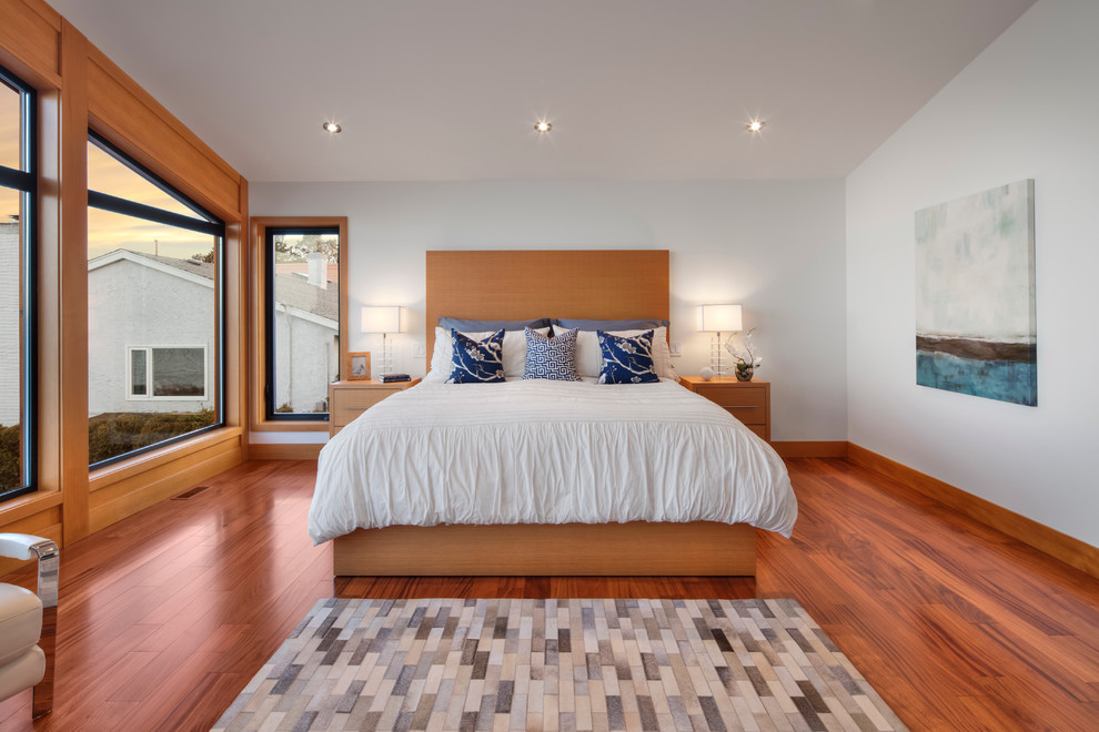 Diseño de dormitorio principal actual grande con paredes blancas y suelo de madera clara