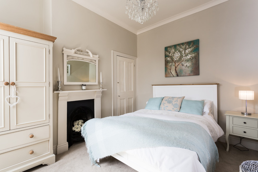 Стильный дизайн: гостевая спальня среднего размера, (комната для гостей) в классическом стиле с серыми стенами, ковровым покрытием, стандартным камином и фасадом камина из металла - последний тренд