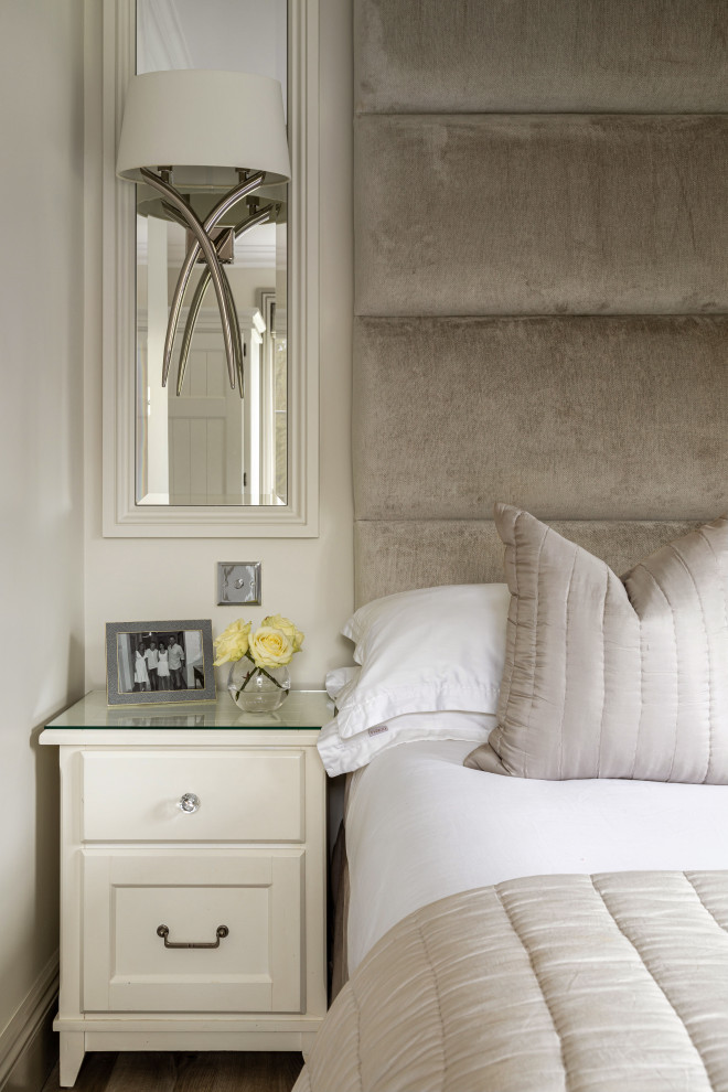 This is an example of a medium sized classic guest bedroom in Essex with white walls, light hardwood flooring and grey floors.