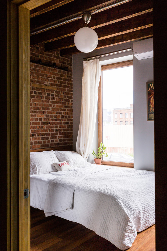 Example of an urban guest medium tone wood floor bedroom design in New York