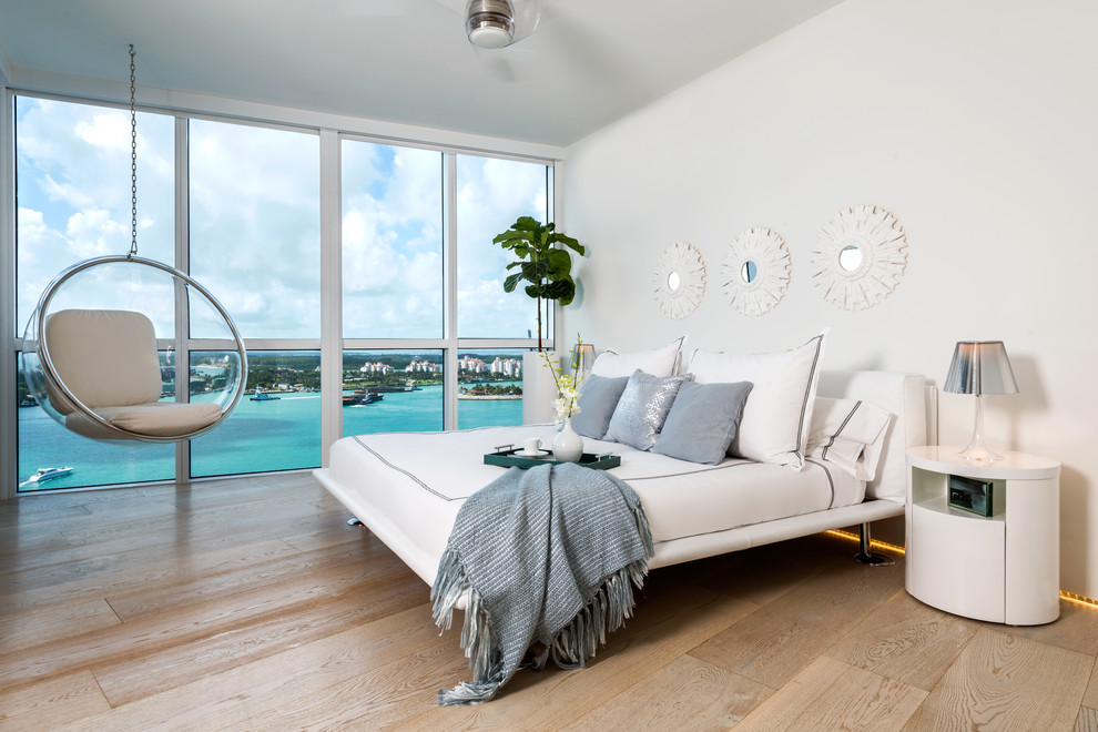 Modelo de habitación de invitados contemporánea grande con paredes blancas y suelo de madera clara