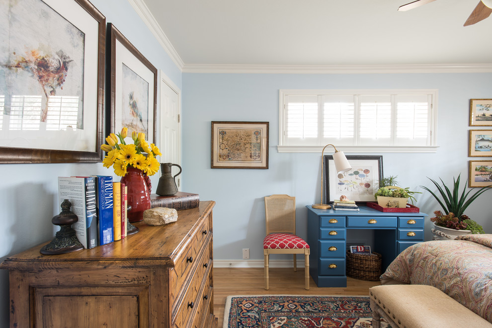 Modelo de habitación de invitados tradicional de tamaño medio con paredes azules y suelo de madera en tonos medios