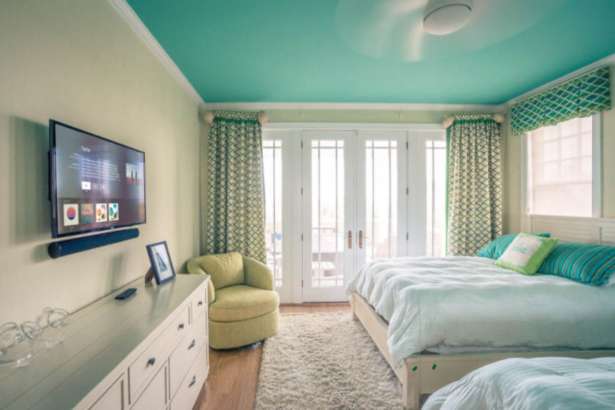 Foto de habitación de invitados marinera de tamaño medio sin chimenea con paredes verdes y suelo de madera clara