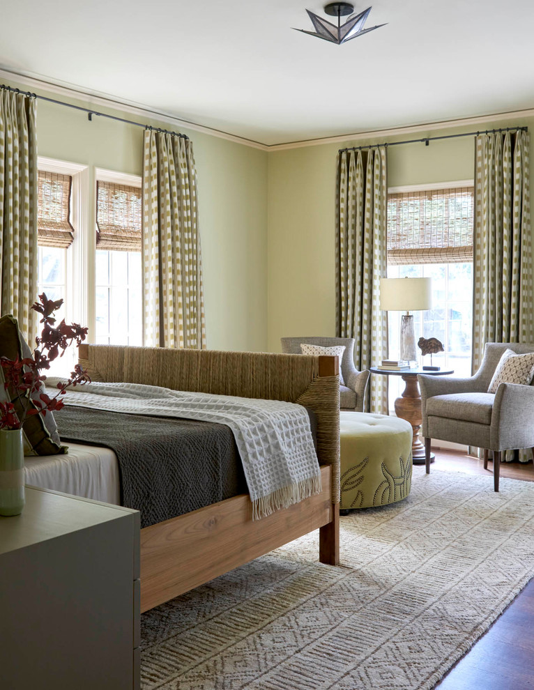 Modelo de habitación de invitados mediterránea de tamaño medio sin chimenea con paredes verdes, suelo de madera en tonos medios y suelo marrón