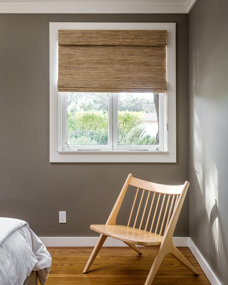Diseño de habitación de invitados minimalista de tamaño medio sin chimenea con paredes grises y suelo de madera en tonos medios