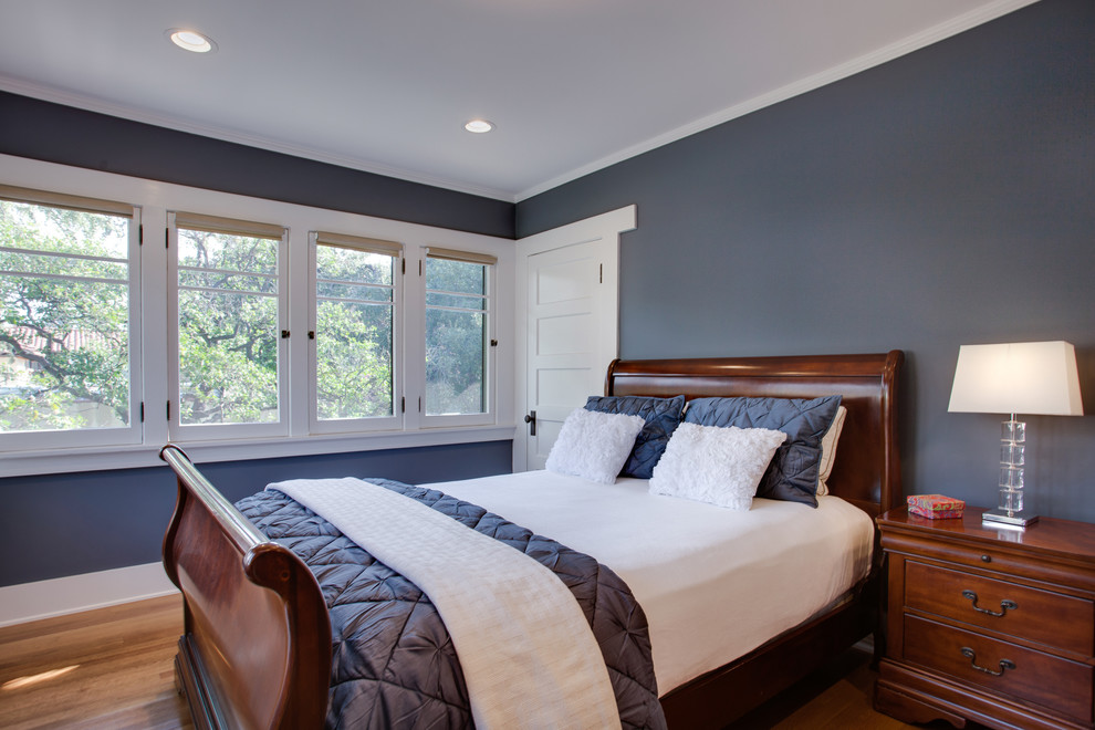 Aménagement d'une chambre d'amis craftsman de taille moyenne avec un mur bleu, un sol en bois brun et aucune cheminée.
