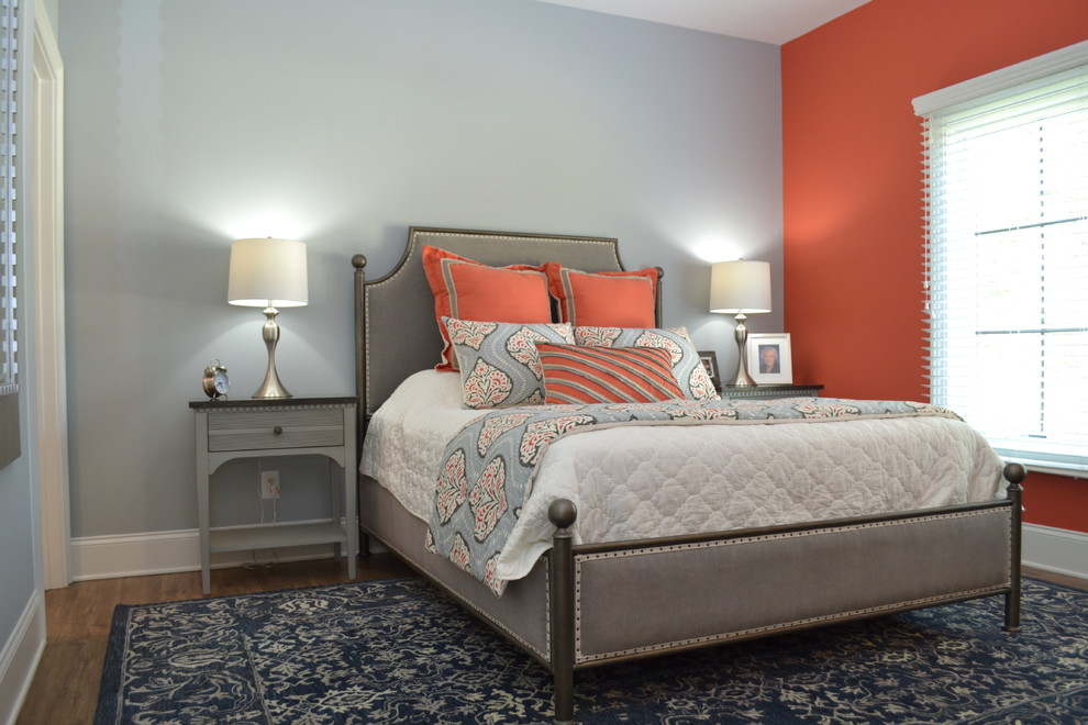 Immagine di una camera degli ospiti chic di medie dimensioni con pareti arancioni, pavimento in legno massello medio, nessun camino e pavimento marrone