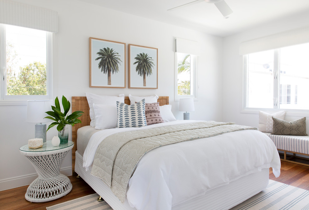 ゴールドコーストにある広いビーチスタイルのおしゃれな客用寝室 (白い壁、無垢フローリング、茶色い床) のインテリア