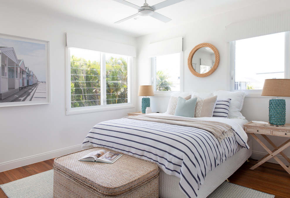 ゴールドコーストにある広いビーチスタイルのおしゃれな客用寝室 (白い壁、無垢フローリング、茶色い床) のインテリア