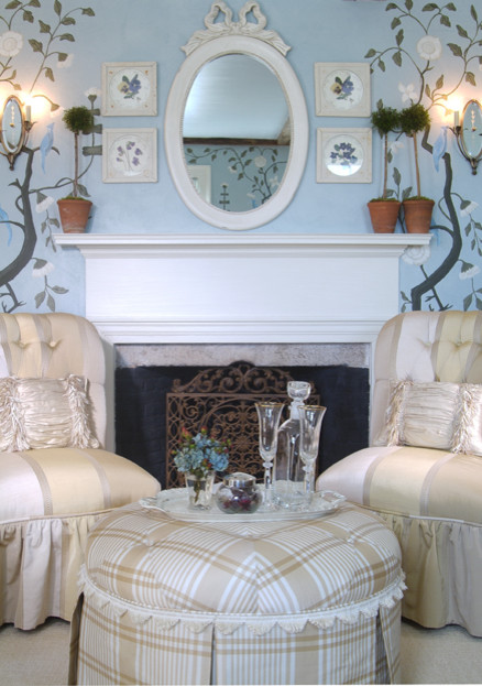 Modelo de habitación de invitados clásica de tamaño medio con paredes azules, suelo de madera en tonos medios, todas las chimeneas y marco de chimenea de madera