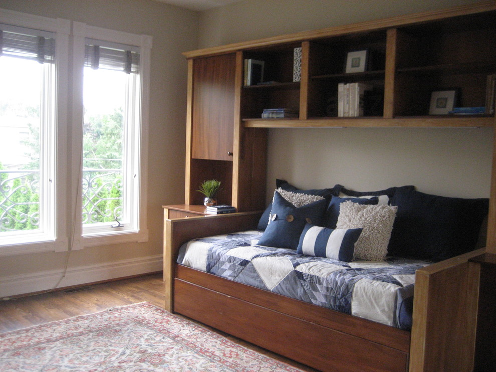 Inspiration pour une grande chambre d'amis traditionnelle avec un mur beige, un sol en bois brun et aucune cheminée.