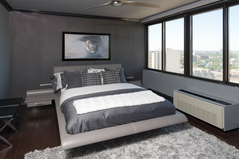 Imagen de dormitorio principal contemporáneo de tamaño medio sin chimenea con paredes grises, suelo de madera oscura y suelo marrón