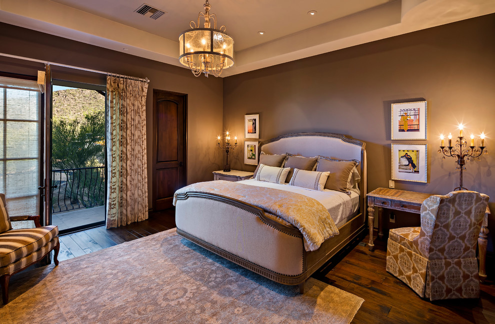 フェニックスにある広いトラディショナルスタイルのおしゃれな主寝室 (ベージュの壁、濃色無垢フローリング、暖炉なし、木材の暖炉まわり) のインテリア