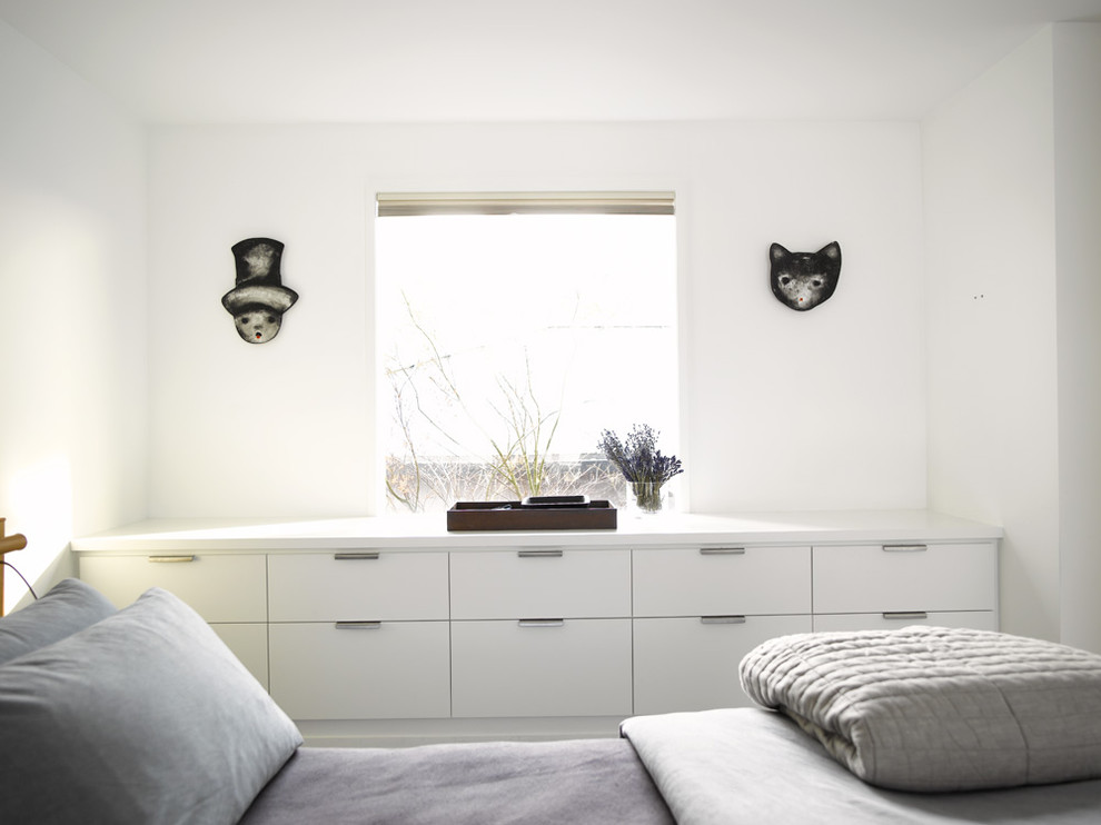 Exemple d'une chambre tendance avec un mur blanc.