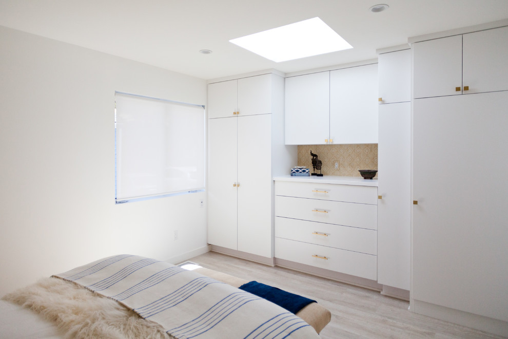 Foto de habitación de invitados marinera de tamaño medio sin chimenea con paredes blancas y suelo de madera clara