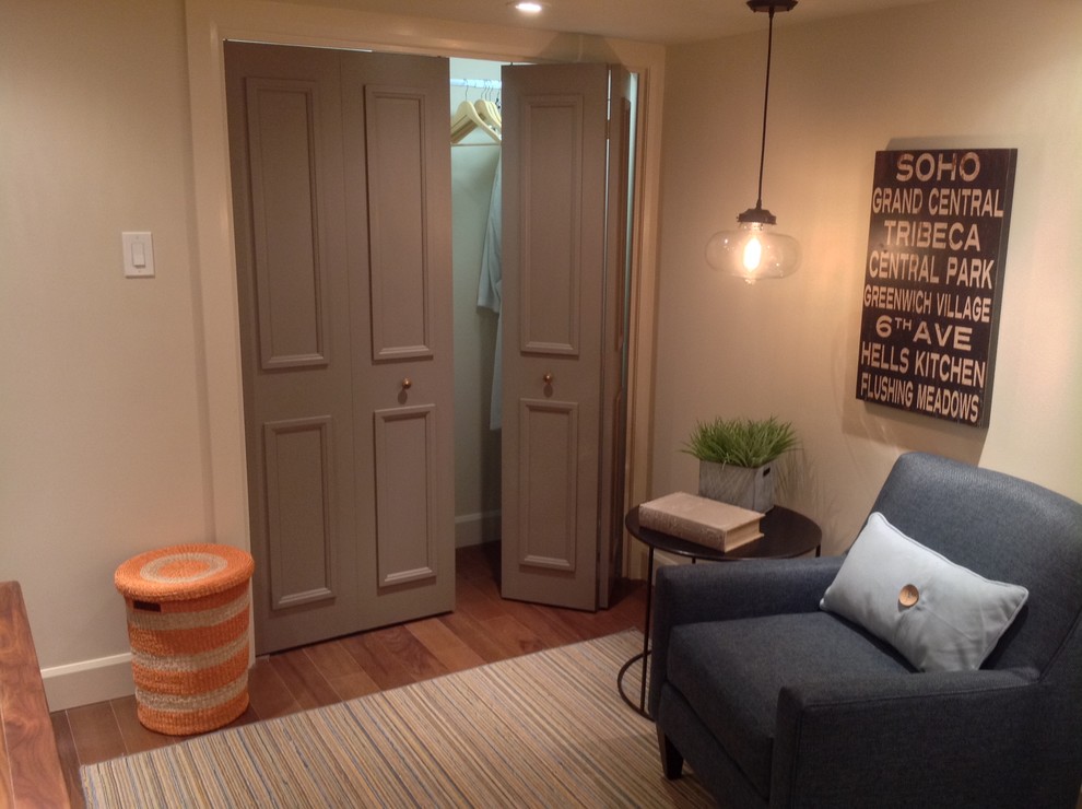 Immagine di una camera degli ospiti minimalista di medie dimensioni con pareti beige e pavimento in legno massello medio