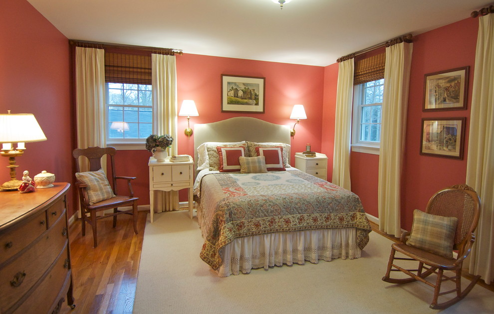 Foto de dormitorio principal tradicional grande sin chimenea con paredes rojas y suelo de madera en tonos medios