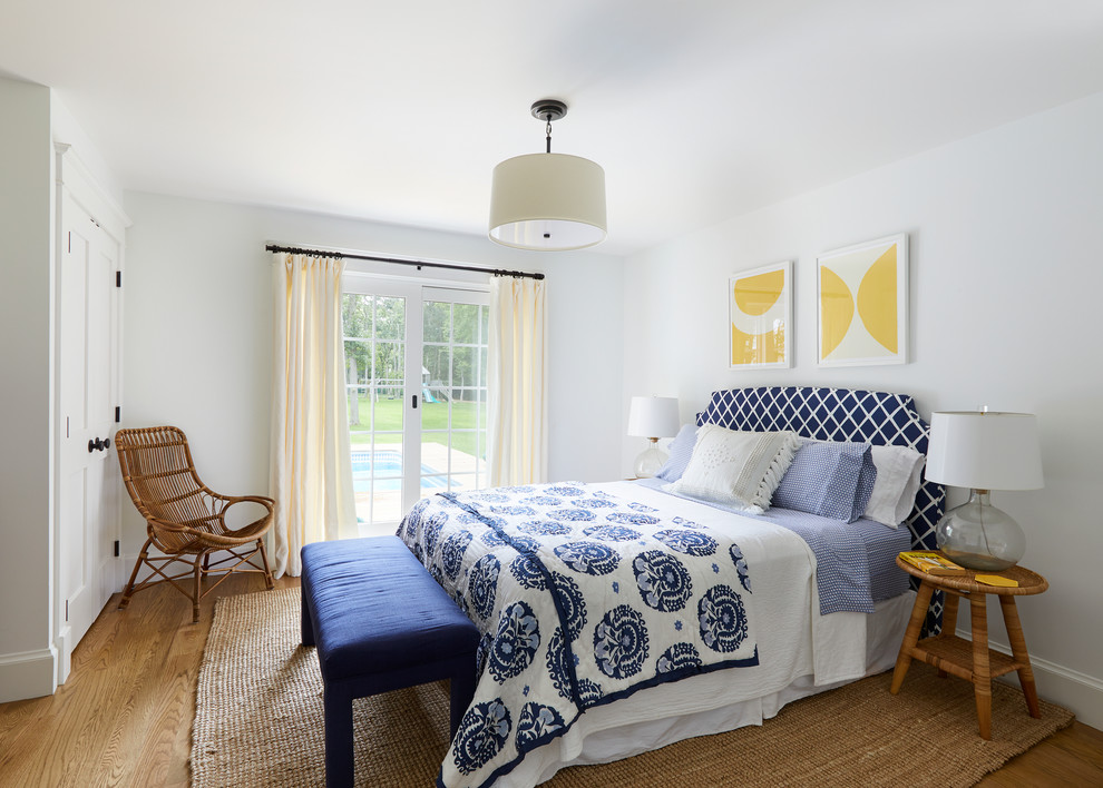 Foto de habitación de invitados costera de tamaño medio con paredes blancas y suelo de madera en tonos medios