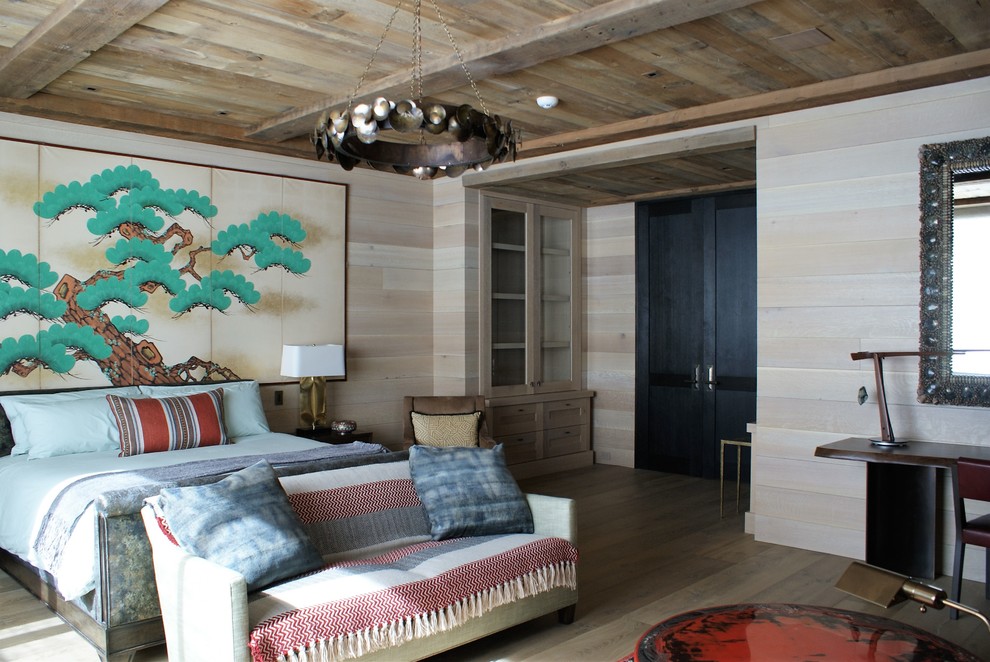 Modelo de dormitorio principal rural de tamaño medio sin chimenea con paredes marrones y suelo de madera clara