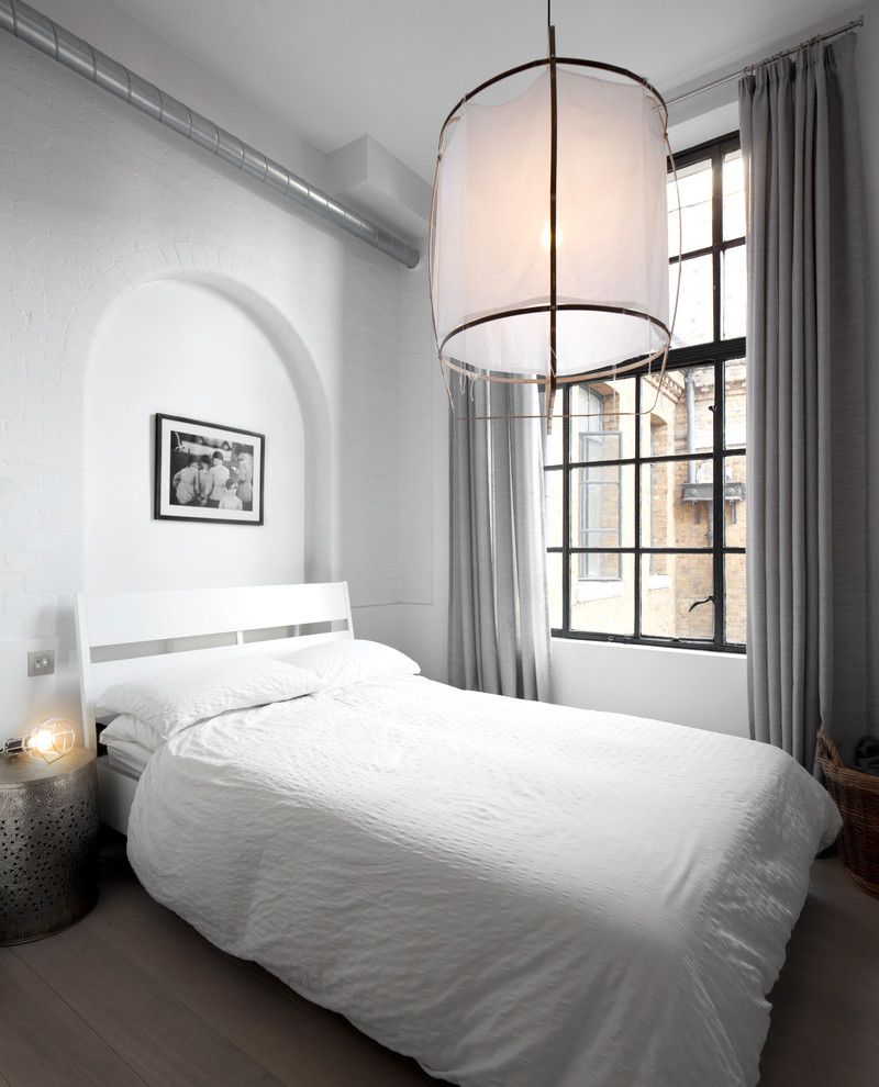 Photo of a scandinavian guest bedroom in London with white walls, light hardwood flooring and no fireplace.