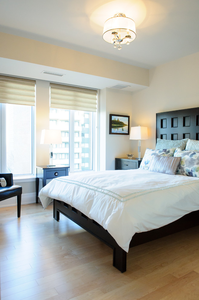 Imagen de habitación de invitados clásica renovada de tamaño medio sin chimenea con paredes beige, suelo de madera clara y suelo beige