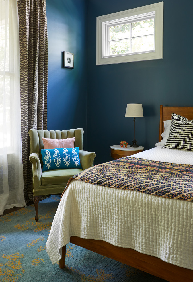 Modelo de dormitorio principal retro de tamaño medio con paredes azules, suelo de madera oscura y suelo marrón