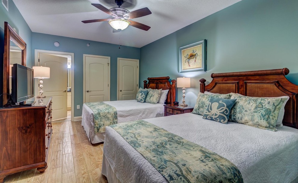 Exemple d'une chambre d'amis bord de mer de taille moyenne avec un mur bleu, un sol en carrelage de céramique et un sol beige.
