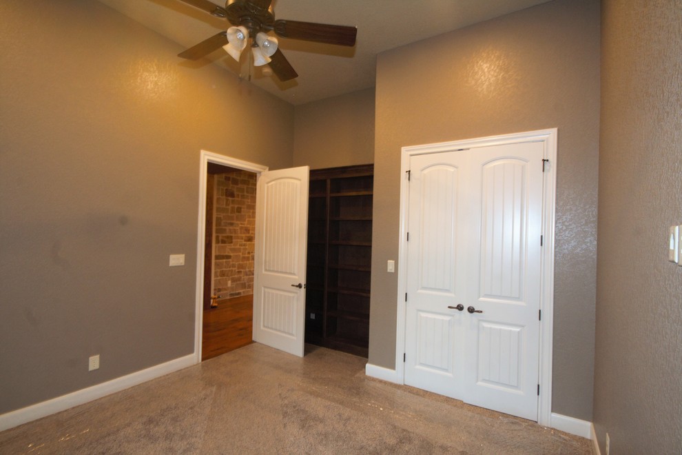 Mid-sized elegant guest carpeted and gray floor bedroom photo in Austin with gray walls and no fireplace