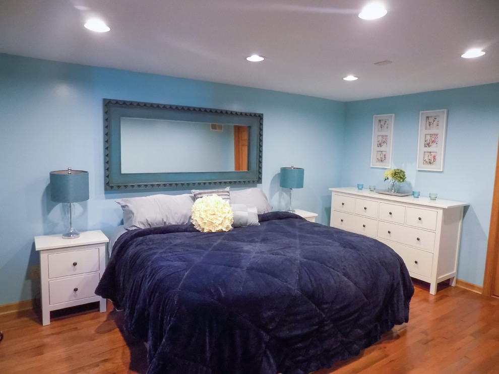 Imagen de habitación de invitados costera de tamaño medio con paredes azules, suelo de madera clara y suelo marrón