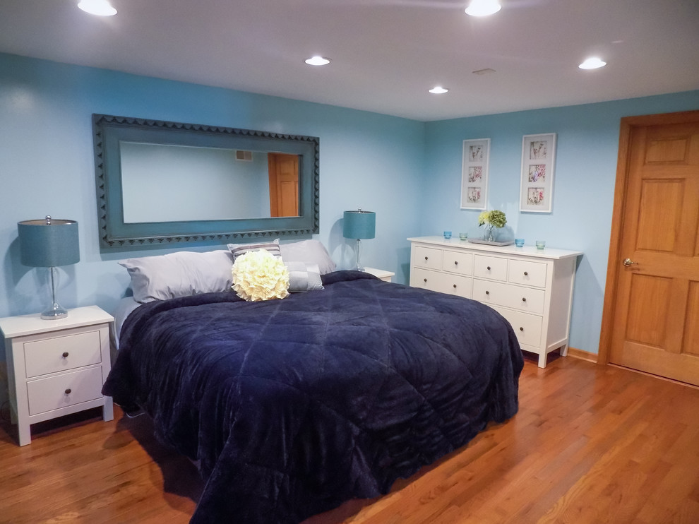 Cette photo montre une chambre d'amis bord de mer de taille moyenne avec un mur bleu, parquet clair et un sol marron.