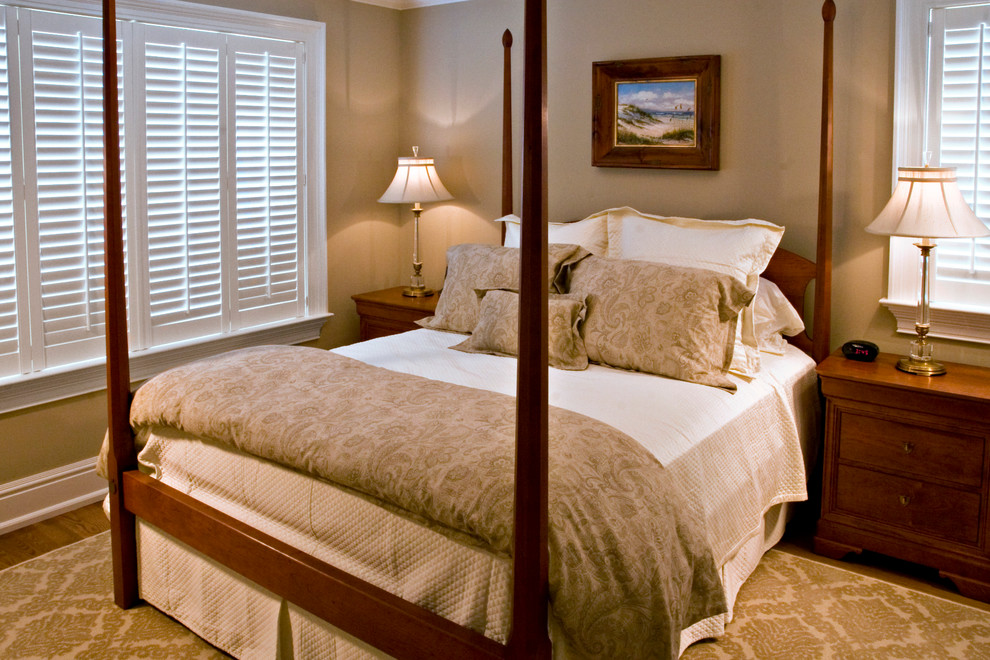 Diseño de habitación de invitados tradicional con paredes beige y suelo de madera clara
