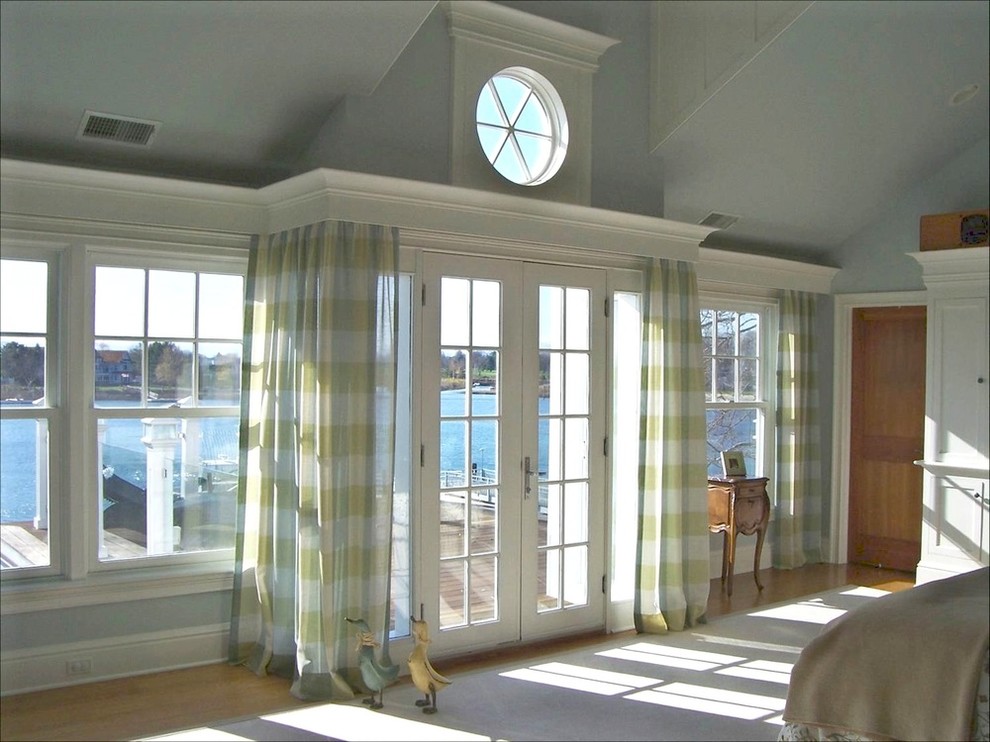 Großes Maritimes Hauptschlafzimmer ohne Kamin mit blauer Wandfarbe, hellem Holzboden und braunem Boden in Bridgeport