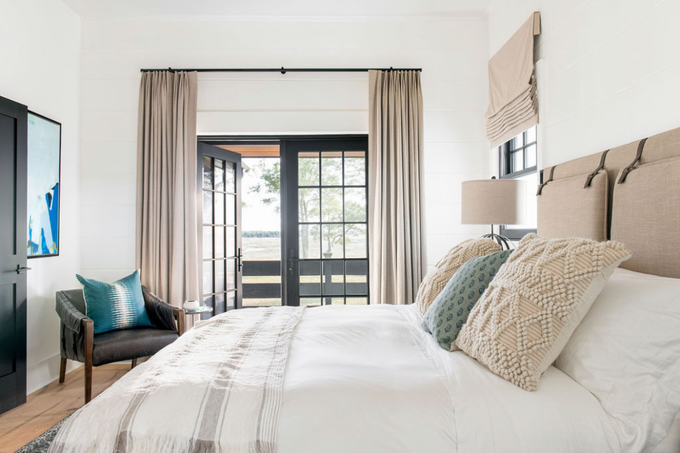 チャールストンにある広いカントリー風のおしゃれな主寝室 (白い壁、淡色無垢フローリング、茶色い床、板張り壁)