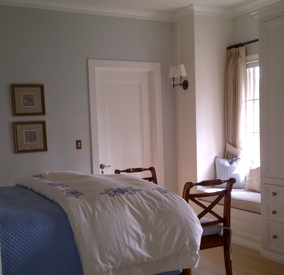 Diseño de habitación de invitados tradicional de tamaño medio con paredes azules y suelo de madera clara