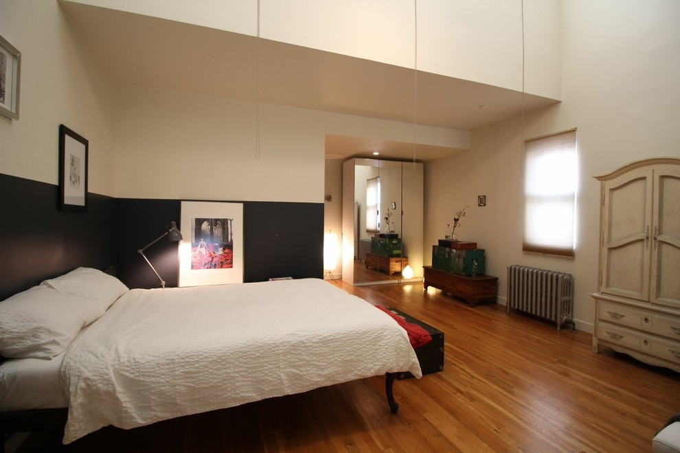 Imagen de habitación de invitados retro grande sin chimenea con paredes beige y suelo de madera en tonos medios