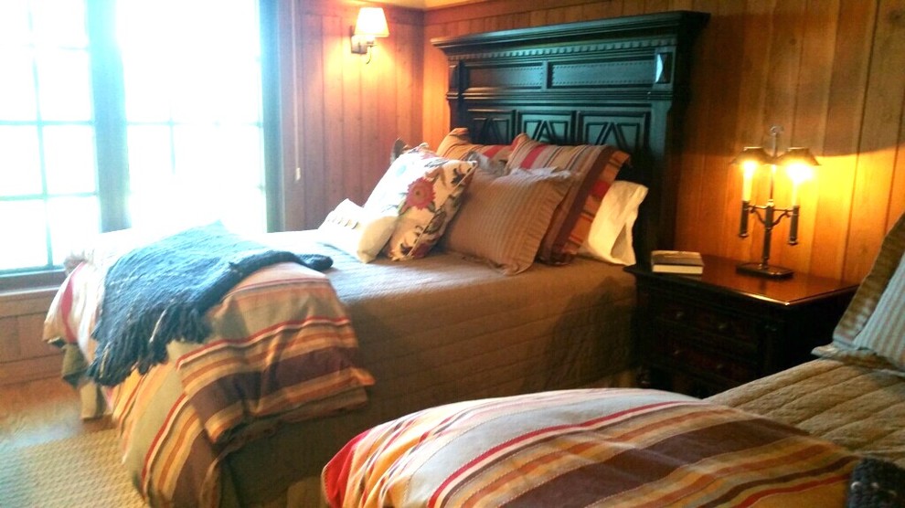 На фото: гостевая спальня среднего размера, (комната для гостей) в стиле рустика с коричневыми стенами, темным паркетным полом и коричневым полом без камина с