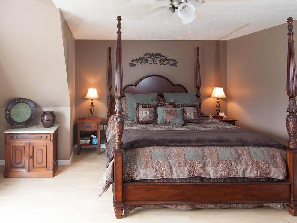 Imagen de habitación de invitados tradicional de tamaño medio con paredes marrones y suelo laminado