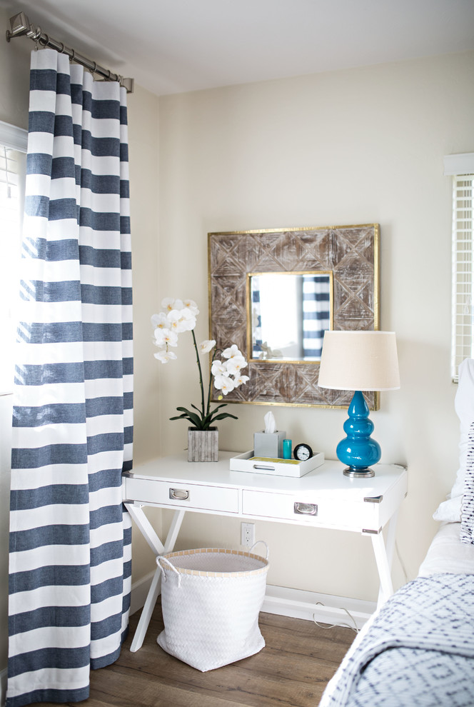 Ejemplo de habitación de invitados minimalista grande sin chimenea con paredes blancas, suelo laminado y suelo beige