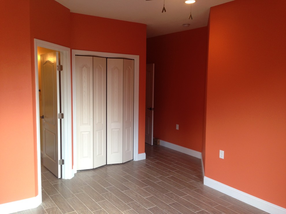 マイアミにある中くらいなトラディショナルスタイルのおしゃれな客用寝室 (オレンジの壁、磁器タイルの床) のレイアウト