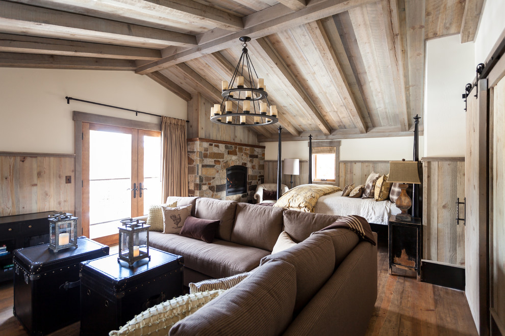 Design ideas for a rustic master bedroom in Sacramento with white walls, medium hardwood flooring, a standard fireplace and a stone fireplace surround.
